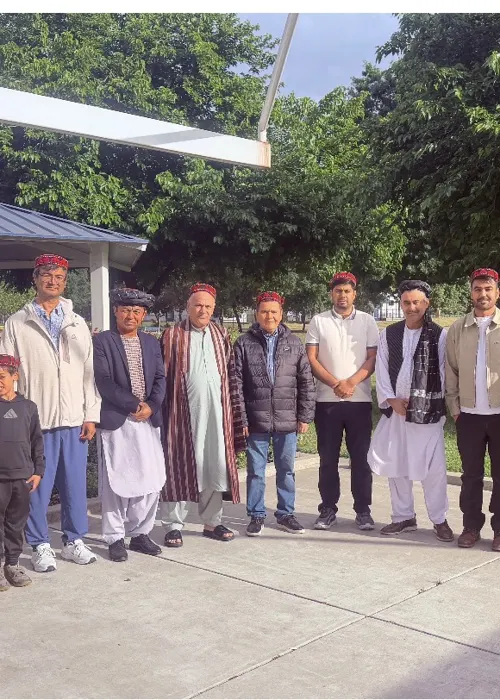 Community members wearing traditional embroidered caps