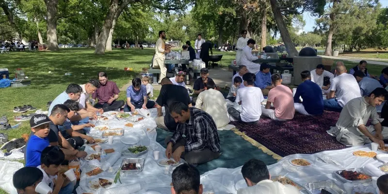 Fathers and children eating together at a community picnic
